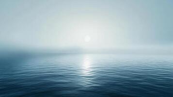 Sunlight reflecting on calm ocean water with light fog creating a serene atmosphere photo