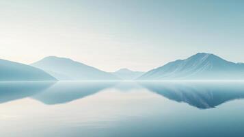 Serene landscape featuring misty mountains reflecting perfectly in a calm lake at sunrise, creating a tranquil and minimalist scene photo