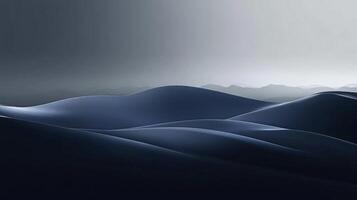 Smooth, undulating blue dunes extend towards a range of misty mountains under a twilight sky photo
