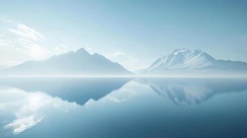 Serene landscape showcasing a snow capped mountain reflecting perfectly on the still water of a lake during a misty morning photo