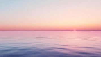 Soft pink and blue hues blend seamlessly in a tranquil sunset over a calm ocean, creating a serene and dreamy atmosphere photo