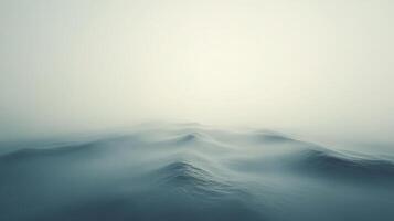 Soft waves are barely visible through thick fog creating a serene and minimalist seascape photo