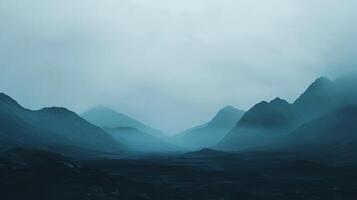 Dark blue mountain range covered by fog at dawn, creating a mysterious and evocative atmosphere photo