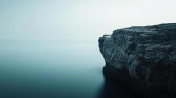 Lone person stands on a dramatic cliff edge, contemplating the vastness of the ocean, creating a serene and introspective atmosphere photo
