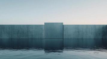 Minimalist concrete wall rising from calm water under a clear blue sky, creating a serene and abstract scene photo