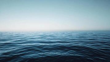 Deep blue ocean waves gently rolling under clear sky, creating a tranquil and serene seascape photo