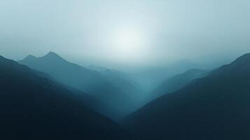 Sunlight illuminating the peaks of a misty mountain range, creating a serene landscape photo
