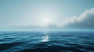 Calm ocean reflecting sunlight on a misty day with clouds photo