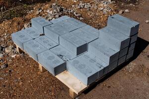 A pile of gray concrete blocks stacked on a pallet at a construction site for building. These durable and solid materials are essential for the projects foundation and structural support photo