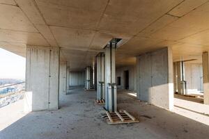A large, vacant building that is currently in the process of construction, showcasing numerous sturdy concrete pillars. This expansive space holds immense potential for a variety of uses photo