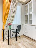 Imagine a cozy kitchen that features a dining table along with chairs, all positioned right in front of a lovely window that allows natural light to fill the space beautifully photo