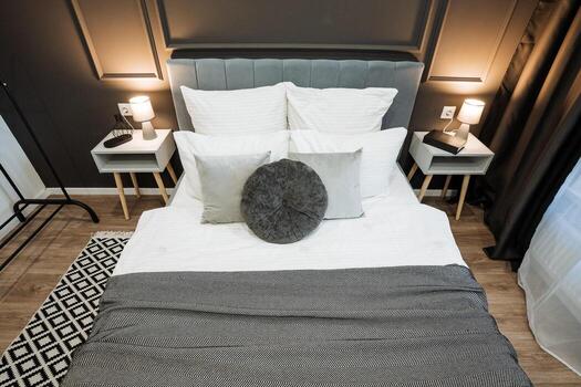 In a cozy bedroom, there is a comfortable bed adorned with crisp white sheets and fluffy pillows, creating a serene and inviting atmosphere ideal for restful sleep and relaxation photo