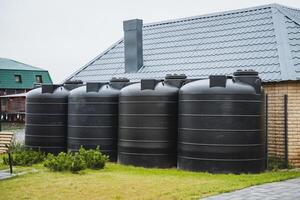 Next to the apartment complex, there are large black water tanks that store and supply water for the residents daily needs, ensuring a reliable water source on site photo