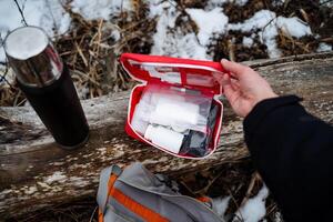 A person tightly grips a first aid kit in their hands, fully prepared to assist in any unexpected emergency situation, demonstrating their commitment to safety and preparedness at all times photo