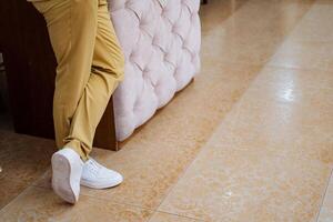 A person is sitting on a couch with their legs crossed photo