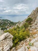 The breathtaking view of the vast ocean from the elevated peak of a rocky mountain offers a stunning panorama that captures the beauty of nature perfectly all around you photo