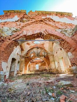 The interior of an ancient brick building is visible, with a beautiful blue sky serving as the backdrop, creating a striking contrast to the weathered structure and its historical charm photo