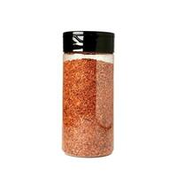 Dried chili flakes seasoning in plastic bottle container packaging isolated on square white background. photo