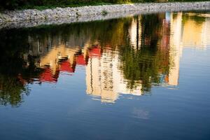 An artistic reflection of a modern building is beautifully mirrored in a tranquil body of water, creating a stunning visual experience that highlights natures serene landscape photo