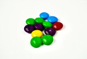 Group of colorful small round rainbow chocolate candy isolated horizontal white background. photo