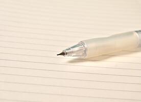 Close up note book with white lined paper and sharp mechanical pencil lead isolated on horizontal background. photo
