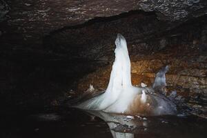 Experience the breathtaking beauty of a majestic ice formation found within a stunning underground cave setting, perfect for adventure seekers photo