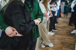 A crowd in formal wear, dancing with fun gestures in a room photo