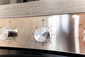 This image features a detailed closeup view of a stainless steel oven, showcasing its various knobs and controls that enhance its functionality and design as a key home appliance photo