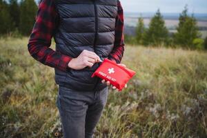 In a tranquil open field, a man holds a first aid kit, ready to help anyone in need. The calming surroundings offer a safe space for those seeking comfort in tough times photo