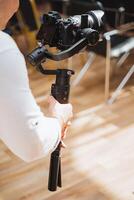 Person setting up camera on tripod for event on wood flooring photo