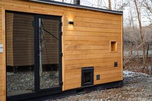 This charming wooden house, featuring a large glass door, warmly invites natural light to flow inside, offering a serene beauty for those who truly appreciate the wonders of nature photo