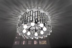 A black and white photo of a chandelier from the ceiling