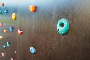 This detailed closeup shot of a climbing wall prominently features a circular hole located at its center, beautifully showcasing the walls unique design, texture, and craftsmanship photo