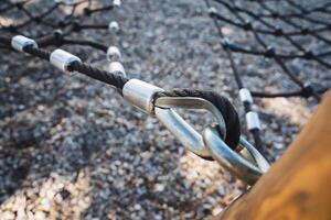 Here we see a detailed closeup of a beautiful rope swing featuring a sturdy carabiner securely attached to it, showcasing the craftsmanship involved and its potential for recreation photo