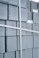 This image showcases a closeup view of stacked concrete blocks, intricately arranged with crossed construction lines, highlighting the vital aspects of various building projects photo