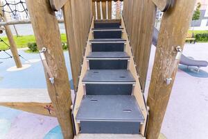 A quaint wooden playground complete with stairs and a slide for fun photo