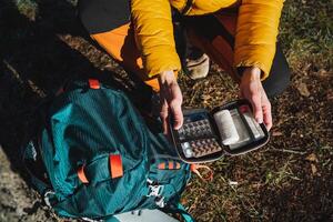 An open first aid kit with medicines, a hiking set of medicines, a minimum set of travel pills, survival in the forest, bushcraft, single adventure. photo