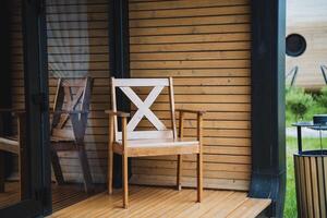 Enhance your modern deck with a Rustic Wooden Patio Chair, creating a cozy and inviting outdoor space with a blend of traditional design, adding charm and a homely atmosphere photo