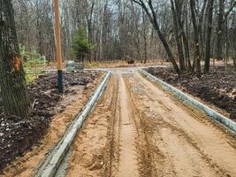 A dirt road is currently in the process of being constructed right in the heart of a beautiful forest surrounded by lush trees and greenery, enhancing access to this natural landscape photo