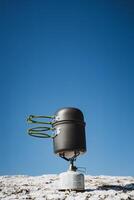 A pot and a pan are currently sitting on top of a propane burner photo