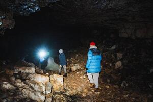 A group of explorers is embarking on an exciting adventure as they navigate through a mysterious cave located deep underneath the Earths surface photo