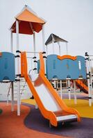 This vibrant and exciting playground features a large, colorful slide and a tall, imaginative structure, all designed specifically for kids to enjoy a safe and fun outdoor recreational area photo