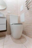 A pristine white toilet is placed in a bathroom adjacent to a sink photo