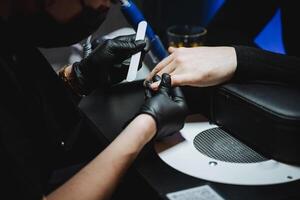 Hand care procedure in a nail salon, top view as a man gets a manicure using the hardware method. photo