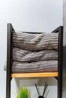 A neatly arranged stack of freshly cleaned and folded towels, perfectly placed, rests on a sturdy wooden shelf, contributing a delightful touch of organization and style to the entire space photo