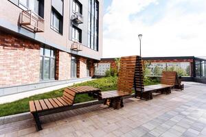 The modern urban bench arrangement in a residential complex is surrounded by abundant greenery and stunning landscaping, fostering a tranquil and harmonious setting photo