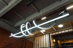 A bright neon light fixture hangs from the ceiling, illuminating the room with a radiant glow and enhancing the ambiance. Its luminous presence adds to the overall atmosphere photo