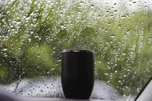A cup by the window catches raindrops, merging indoor and outdoor elements, creating a tranquil atmosphere, connecting the room with nature. A blend of interior and exterior spaces photo