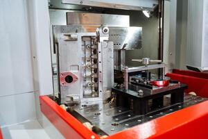 In a factory setting, a specific machine is actively engaged in processing a piece of metal, transforming it for further use or production. This is a crucial step in manufacturing photo