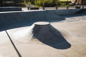 A skilled skateboarder is enthusiastically riding down a steep ramp at a vibrant skate park, showcasing their talent and enjoying the thrill of the ride in an exciting urban environment photo
